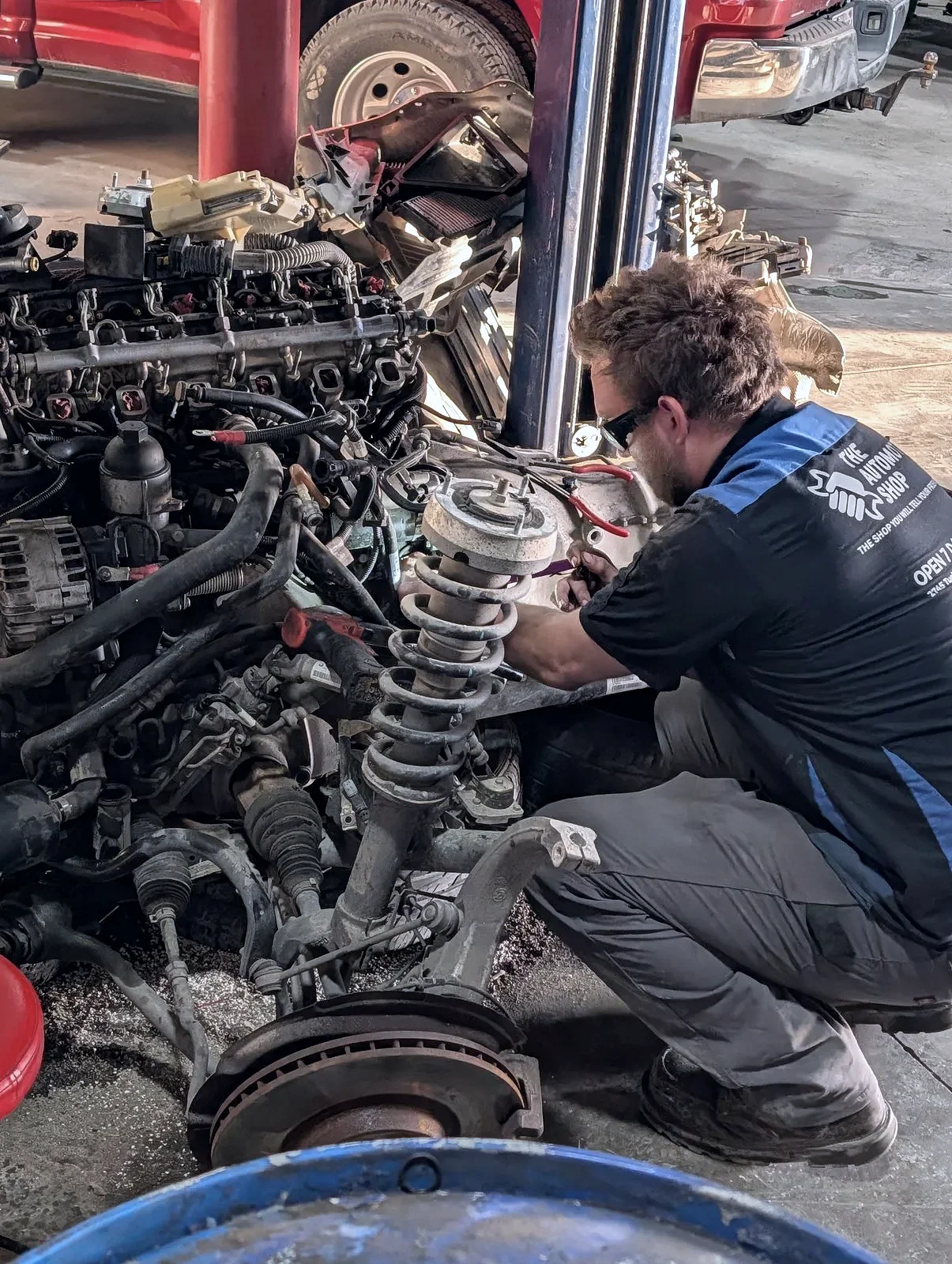 A technician in uniform on an engine rebuild at The Automotive Shop in Jerome, Idaho